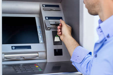 Hand of man with credit card, using a ATMの写真素材