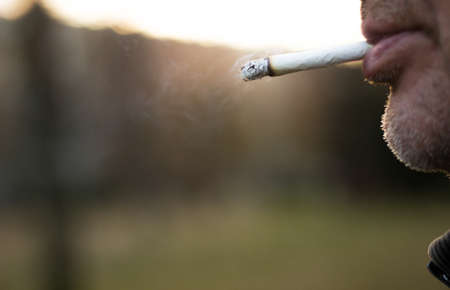 Senior man enjoying a cigarette, outdoorsの写真素材