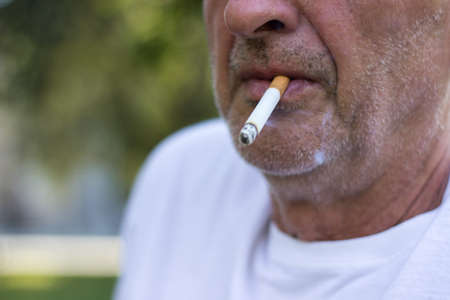 Senior man enjoying a cigarette, outdoorsの写真素材