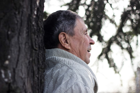 Portrait of happy senior man smiling, in the public park, outdoors.. Old man relaxing outdoors and...