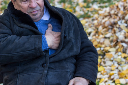Senior man suffering from heart attack, outdoors. Elderly man having chest pains or heart attack in...