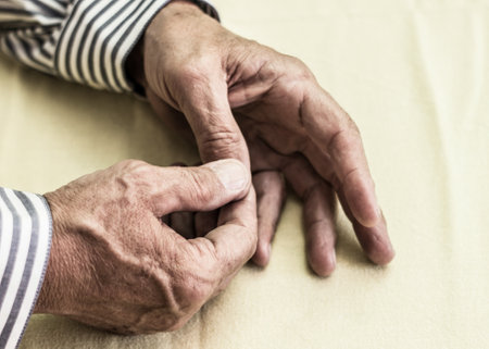 Elderly man has pain in fingers and handsの写真素材