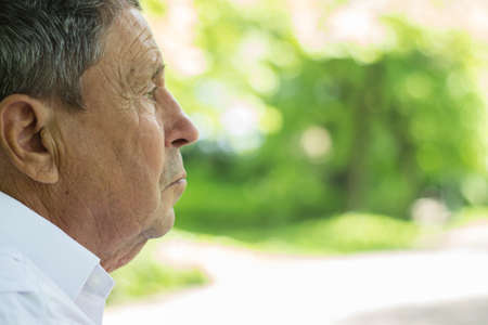 Portrait of a Pensive senior man Outdoors, looking awayの写真素材