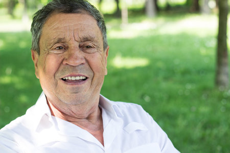 Portrait of a smiling senior man in Nature, looking away