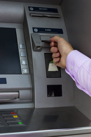 Hand of man with credit card, using a ATM