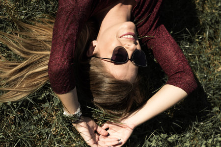 Young smiling woman lying on the grass. In the meadowの写真素材