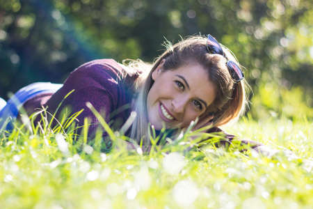 Beautiful young blonde lying in the field. Relaxed woman among nature, young woman relaxing in the grassの写真素材
