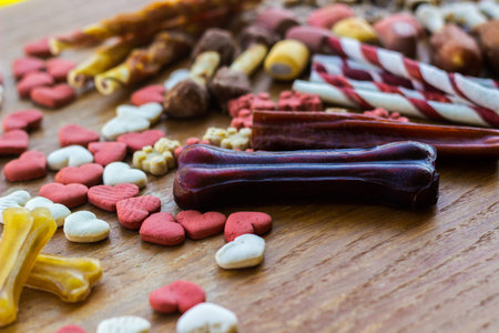 Dog tasty colored biscuits on wooden background with copy space