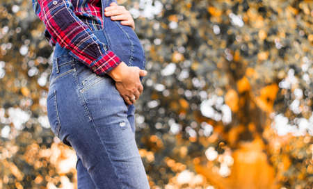 Beautiful pregnant woman touching her belly with handsの写真素材