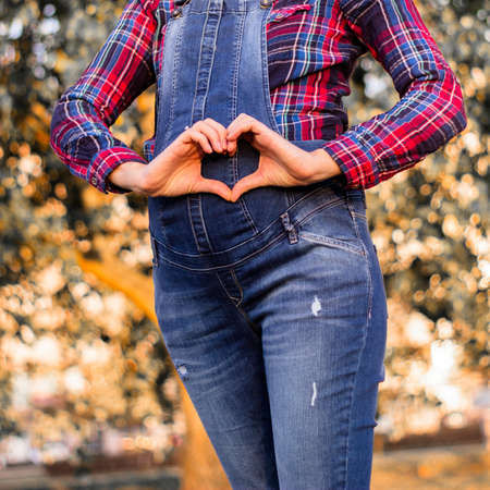 Beautiful pregnant woman touching her belly with handsの写真素材