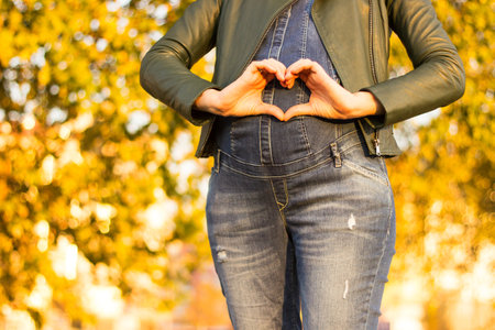 Beautiful pregnant woman touching her belly with handsの写真素材