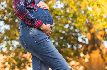 Beautiful pregnant woman touching her belly with hands