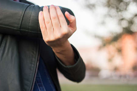 Young woman with Elbow pain, bokeh backgroundの写真素材