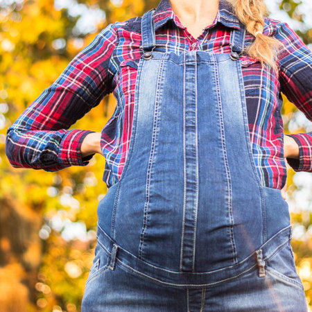 Beautiful pregnant woman touching her belly with handsの写真素材