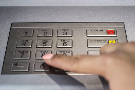 Woman hand typing security code on atm machine