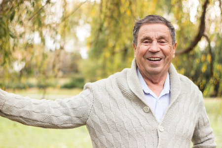 Portrait of a smiling senior man in an autumn park