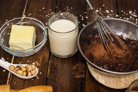 Cake baking ingredients. Ingredients for cooking chocolate pastry from above on wooden background