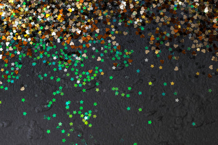 Multicolored glitter background for Christmas and other celebrations. Black background. For variety of topics like Christmas, luxury, success, celebrationの写真素材