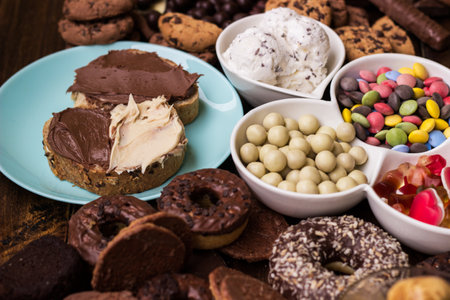 Chocolate cream on a bread and colorful sweets and candiesの写真素材