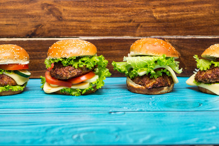 Delicious hamburgers on wooden tableの写真素材