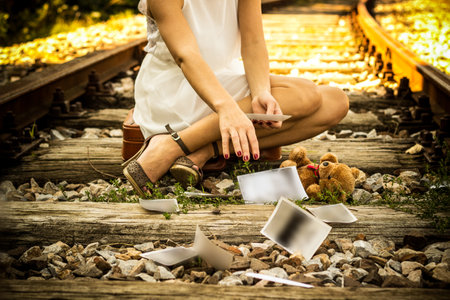 <p>Woman on a railway line with old photographs</p>の写真素材