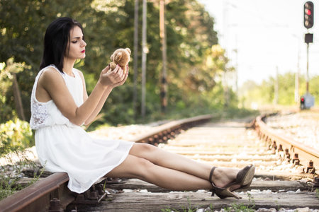 <p>Lonely and sad girl sitting on the railway and looking photos</p>の写真素材