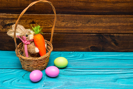 Easter bunny with eggs on wooden wall with copy spaceの写真素材
