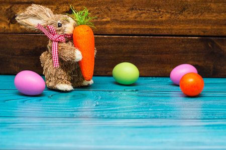 Easter bunny with eggs on wooden wall with copy spaceの写真素材