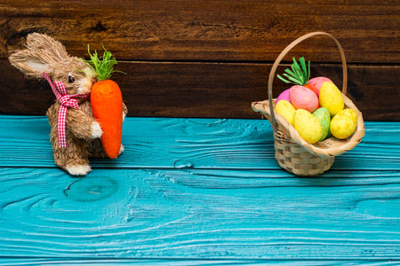 Easter bunny with eggs on wooden wall with copy spaceの写真素材