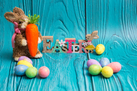 Easter bunny with eggs on wooden wall with copy spaceの写真素材