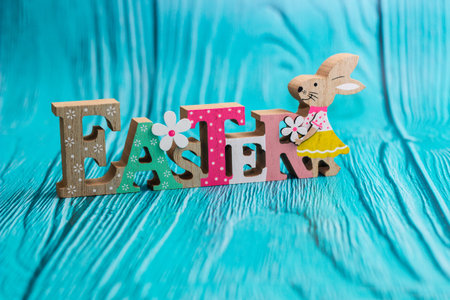 Easter bunny with eggs on blue wooden wall with copy space