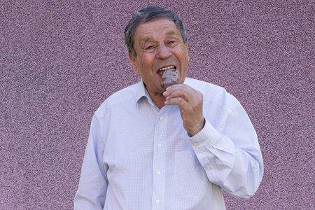 Senior Man indulging in the simple pleasures of life with delicious Chocolate Ice Creamの写真素材