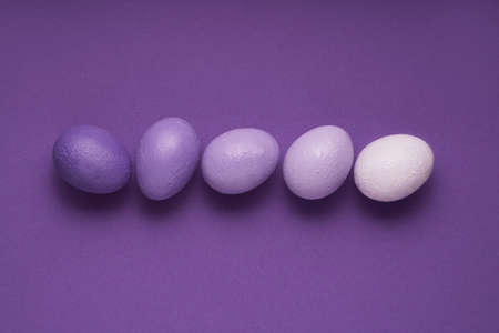 Purple colored Easter eggs on very pery purple background. Creative minimal concept. Pastel colors and soft shadows.の写真素材