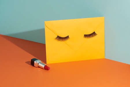 Yellow envelope with make up against pastel background. Creative mail concept.の写真素材
