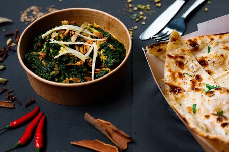 Indian food on a dark background, in paper utensils, photos for menus and advertising. Additives and spicy spices.の写真素材