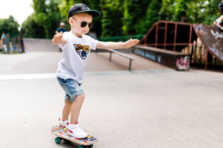 Boy with a skate in a skate park. A boy with glasses learns to skate.の写真素材