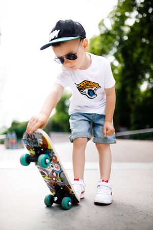 Boy with a skate in a skate park. A boy with glasses learns to skate.の写真素材