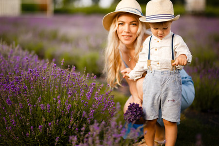 Little boy walking with his mother on a lavender field.