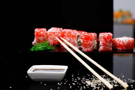 Sushi with salmon. Soy sauce, red caviar. Sushi on a black background.の写真素材