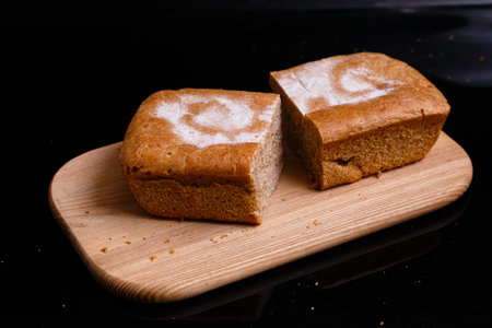 Homemade gray bread on a black background. Photo in section.