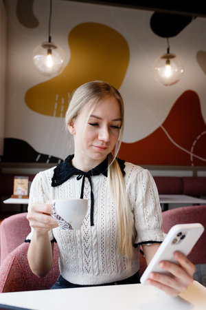 A girl works at a computer in a coffee shop.の写真素材