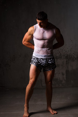 Athlete bodybuilder trains in the studio in the rain.の写真素材