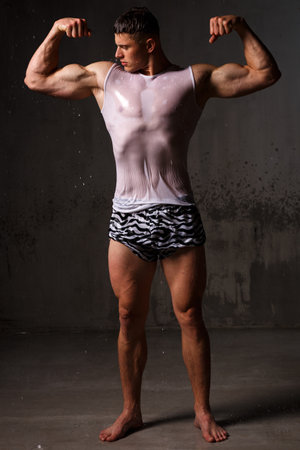 Athlete bodybuilder trains in the studio in the rain.の写真素材