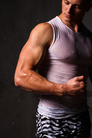 Athlete bodybuilder trains in the studio in the rain.の写真素材