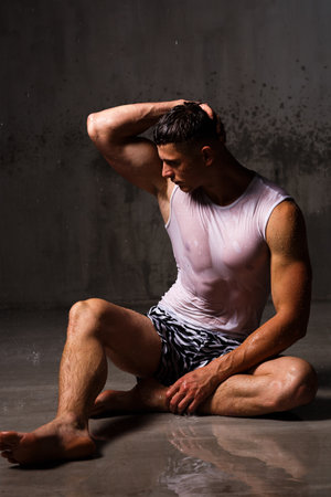 Athlete bodybuilder trains in the studio in the rain.の写真素材