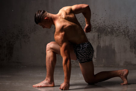 Athlete bodybuilder trains in the studio in the rain.の写真素材