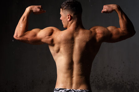 Athlete bodybuilder trains in the studio in the rain.の写真素材