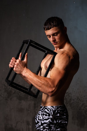 Athlete bodybuilder trains in the studio in the rain.の写真素材