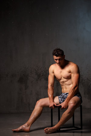Athlete bodybuilder trains in the studio in the rain.の写真素材