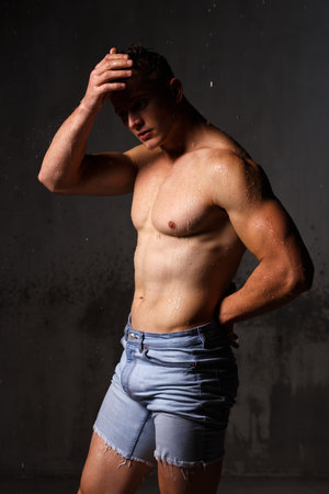 Athlete bodybuilder trains in the studio in the rain.の写真素材